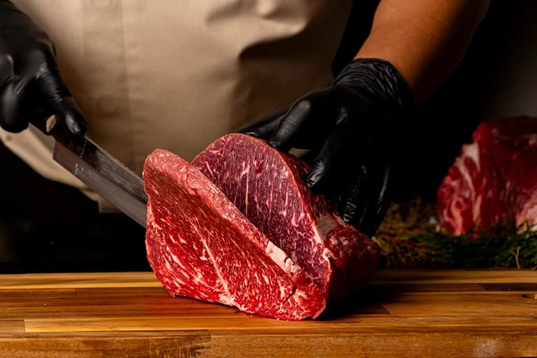 A Chef is cutting wagyu meat.